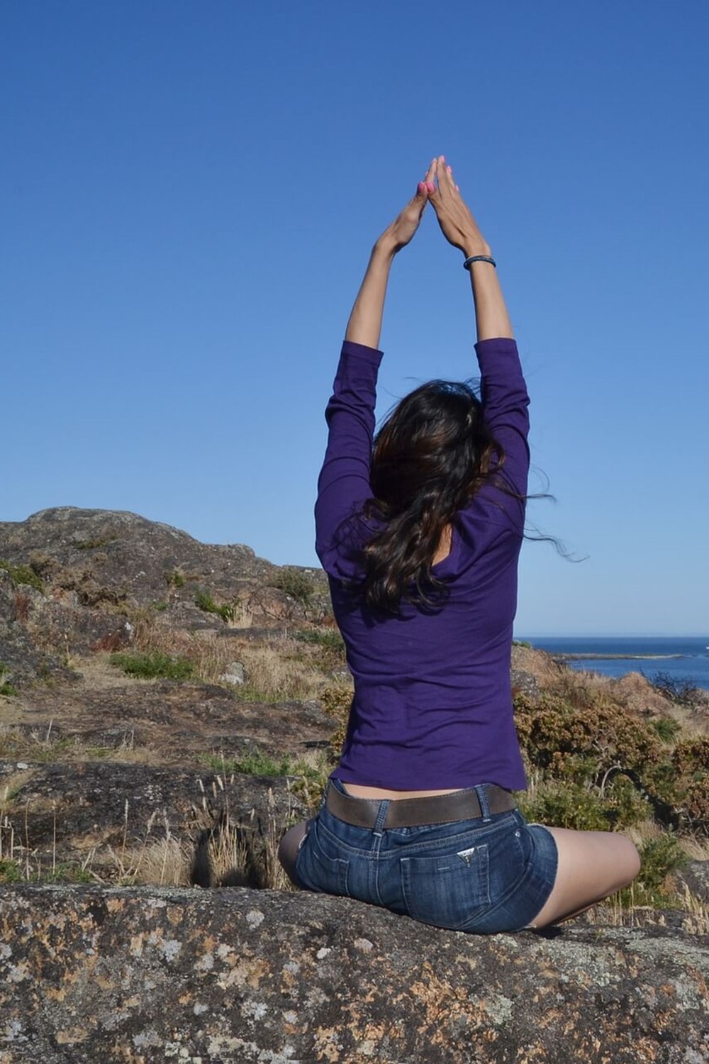 Kvinde i yogastilling på klippe.jpg